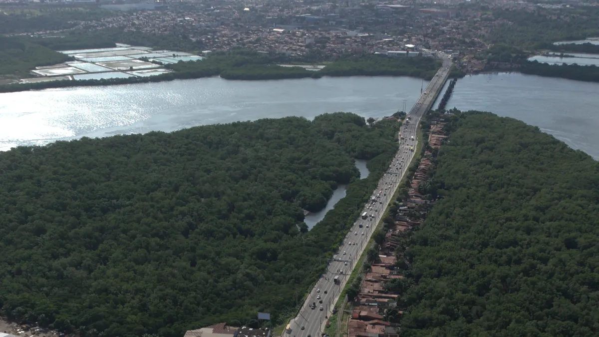 Vista aérea da Avenida Felizardo Moura cortando o manguezal em direção à ponte